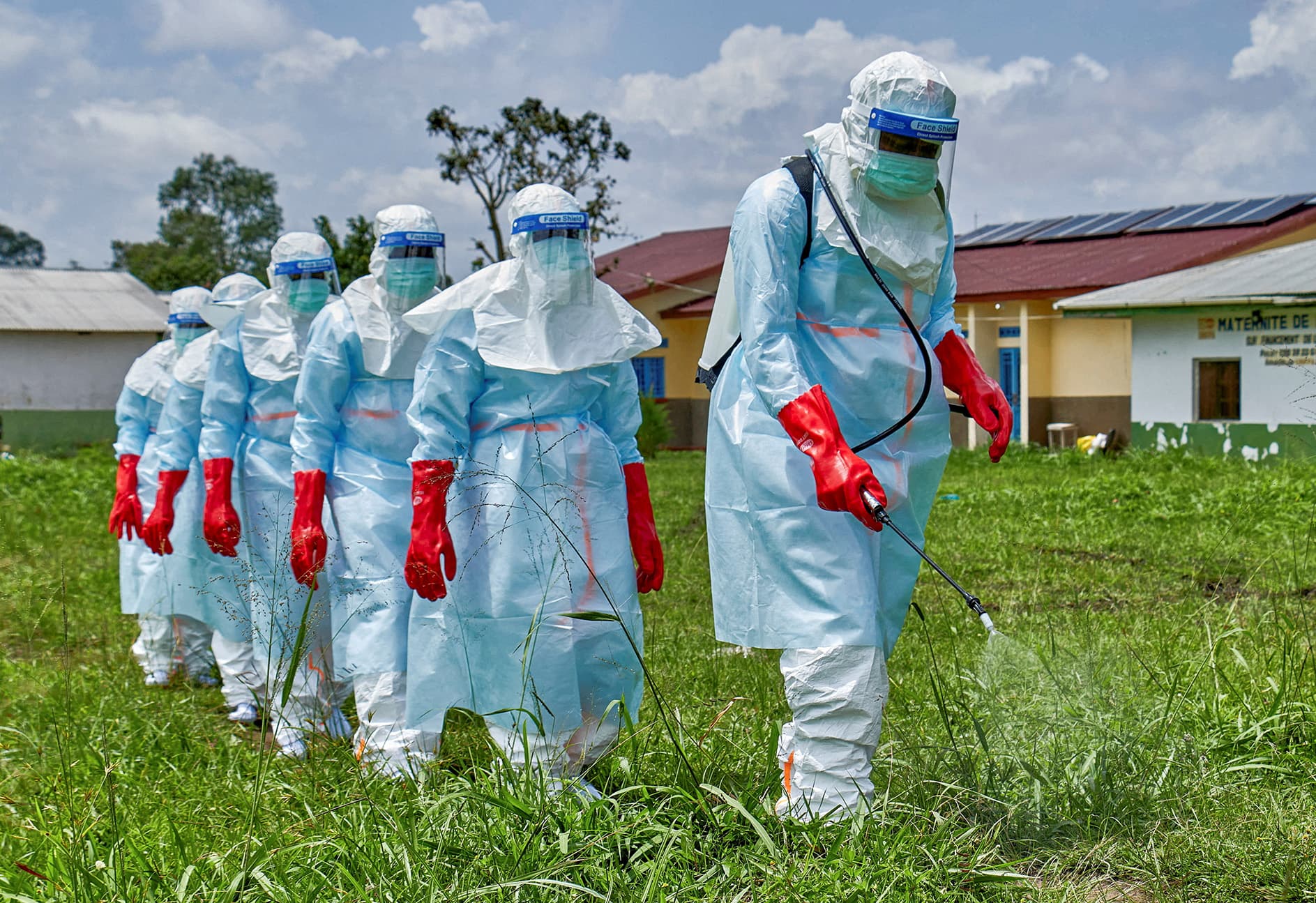 Red Cross workers walk in a formation as they disinfect Rwampara general hospital before handling the body of a person who died of Ebola, as aid agencies intensify efforts to contain a new Ebola outbreak involving the Bundibugyo strain, in Rwampara outside Bunia, Ituri province, Democratic Republic of Congo, May 21, 2026.